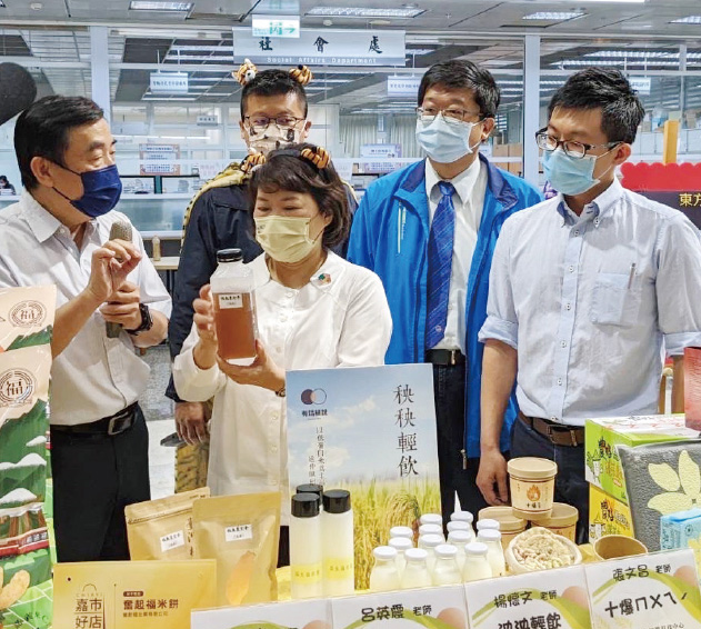 食品科學系許成光主任(左1)向黃敏惠市長介紹黑豆米茶