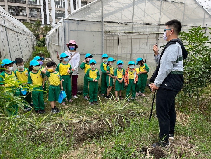 農藝學系四年級學生胡璨陽向志航國小學童介紹新民溫室
