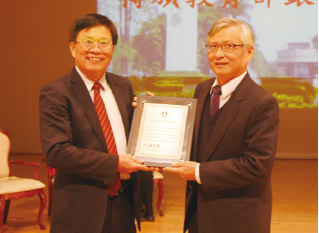 邱義源校長（左）轉頒「教育部捐贈銀質獎牌」給王明純董事長