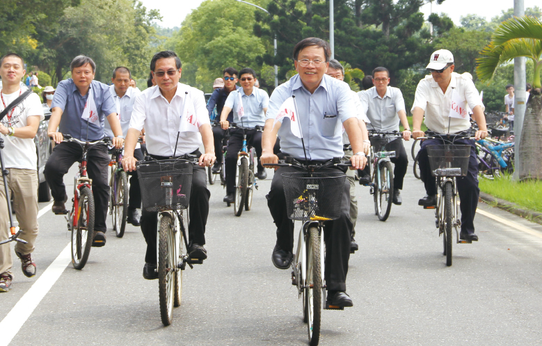 邱義源校長(前右)、涂醒哲市長(前左)與嘉大師生騎乘綠能代步車