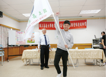 艾群校長授旗予農藝志工隊代表董宴忻同學