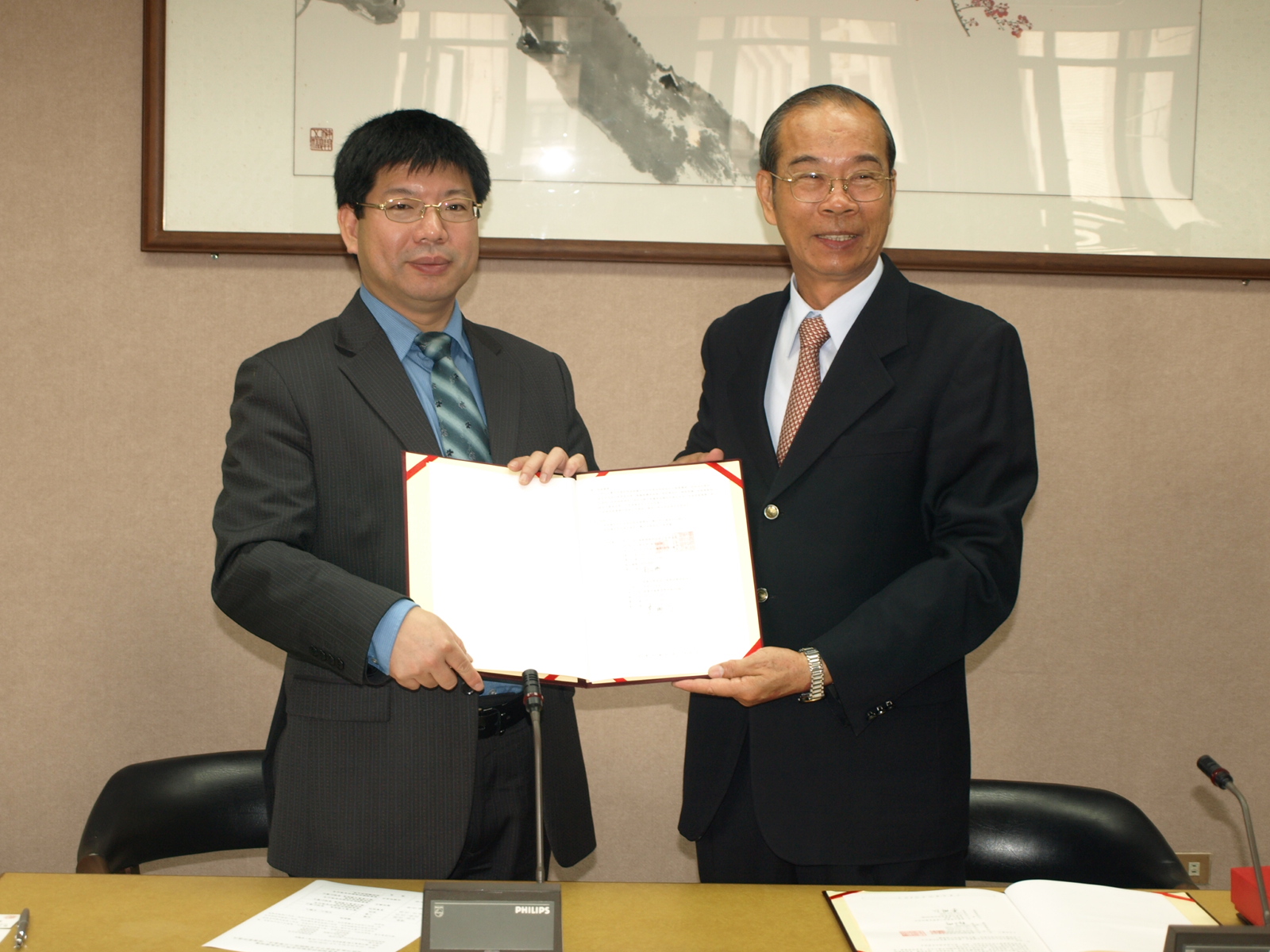 李明仁校長(右)與郭文琦執行副總(左)代表簽訂無償授權合約