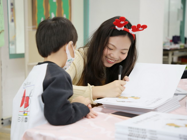 Tsai Pei-Shan, allumna of the NCYU Department of Applied Chemistry and author of the picture book, came back to her alma mater to sign new books for each pupil.