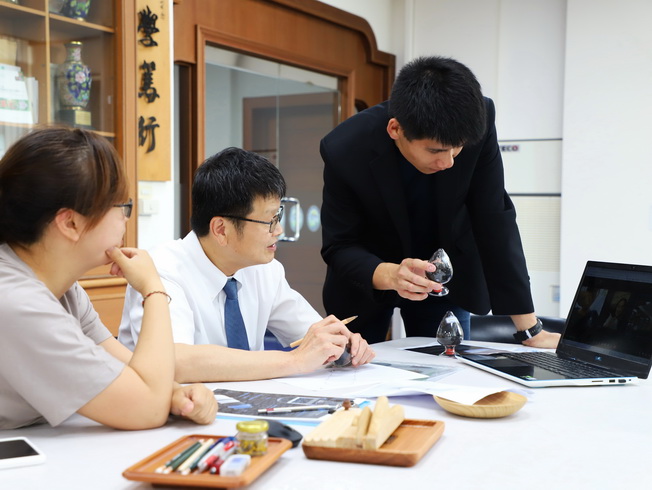 The Environmental Functional Materials Research Lab team of the NCYU Department of Wood Based Materials and Design discussed a design work. (From left to right: Xie Wan-Ting, a Ph.D. student in agricultural science; NCYU President Han Chien Lin; and undergraduate alumnus Lin Yu-Ting)