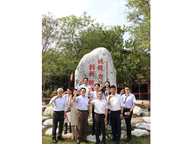 日本姊妹校中京大學貴賓與校內師長於嘉大百年紀念碁石前合影。（照片由國際處提供）