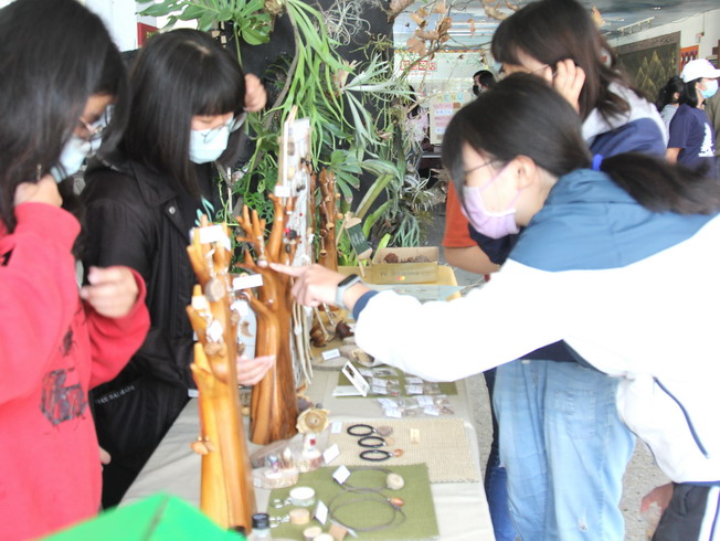  Students stopped to appreciate the display of various exquisite handicrafts made of seeds for sale. 