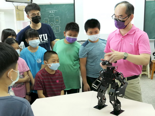 嘉大蘇炯武教授(右)示範鋼鐵機器人。(照片由老師提供)
