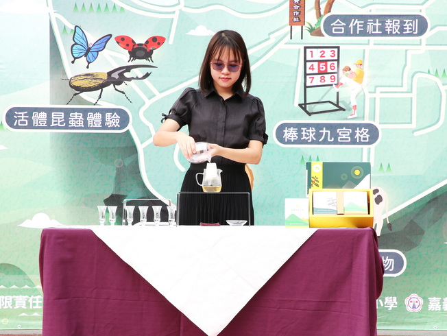 意豐城長女洪鳳茹為嘉大農管學士學程學生現場示範沖泡「嘉大茗茶」。