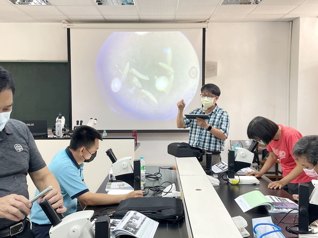 植物醫學副教授系兼農業推廣中心林明瑩主任教導學員利用顯微鏡觀察害蟲形態。（照片由主辦單位提供)