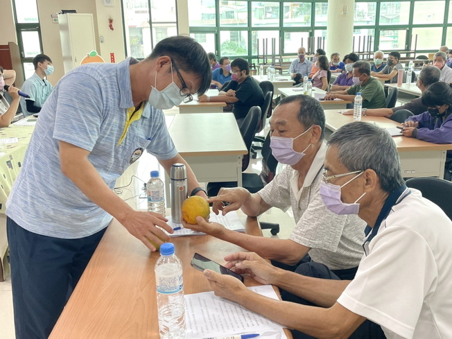 嘉大林明瑩主任(左)向果樹產銷班吳瑞權班長(中)解說柑橘果實發生的病蟲害。（照片由主辦單位提供)