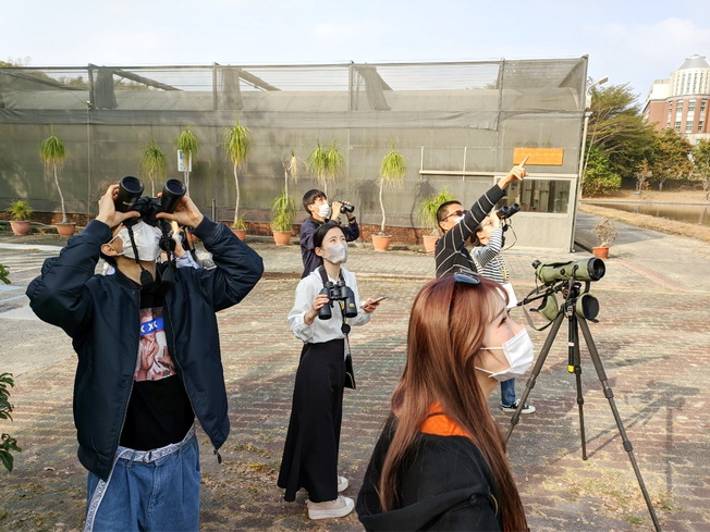 日本學生藉由臺灣鳥類之多樣性及保育課程於蘭潭校區賞鳥。（照片由國際處提供）