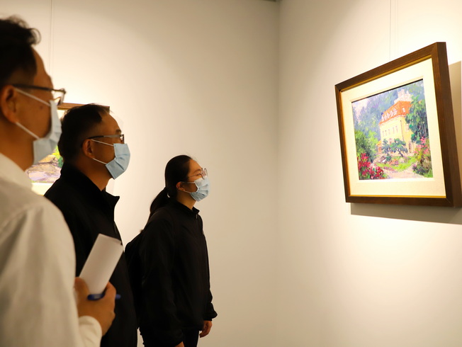 嘉大視覺藝術學系兼圖書館館長廖瑞章教授(中)為觀展學生說明潘蓬彬教授作品特色。