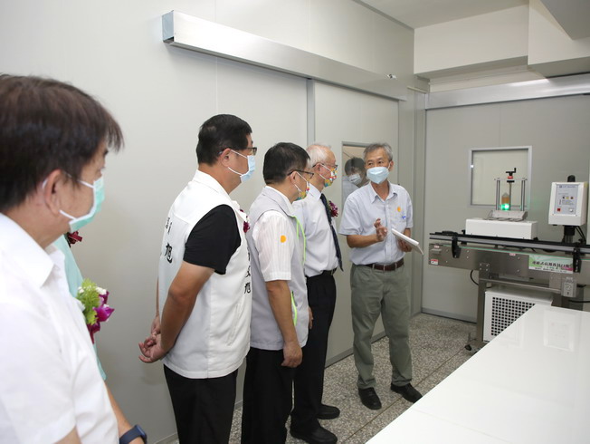 Jan-Jeng Huang (first from right), Director of the NCYU Office for Academia-Industry Collaboration and Continuing Education, introduced the continuous high-frequency sealing machine featured at the proofing center. 