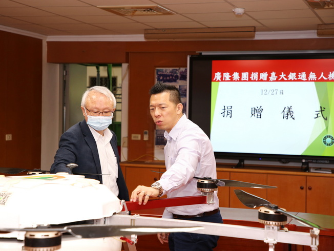 廣隆集團黃南雄總經理(右)向嘉大艾群校長解說45公斤級巨無霸植保機研發技術。