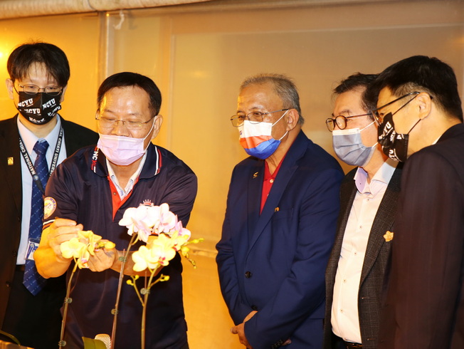 嘉大農學院沈榮壽院長(左2)向參訪貴賓示範蘭花授粉。