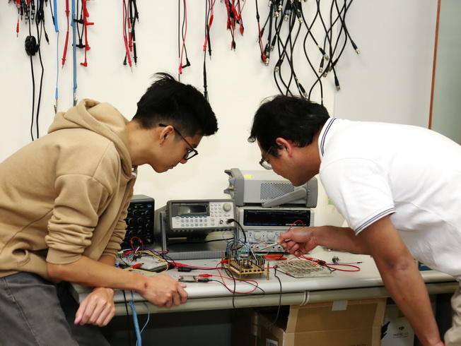 The advisor discussed with the student on chip routing on the circuit board during the experiment.