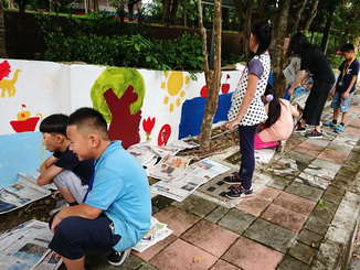 嘉大外語系學生指導學童於圍牆上繪畫