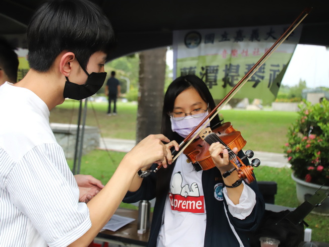 蘭潭提琴社學員現場指導大一新鮮人體驗拉小提琴。