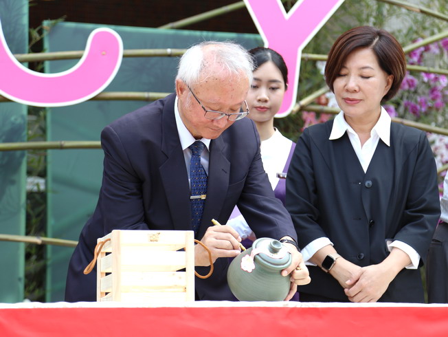 Witnessed by Deputy Mayor Chen Shu-hui (right), NCYU President Chyung Ay (left) signed on the earthenware pot.