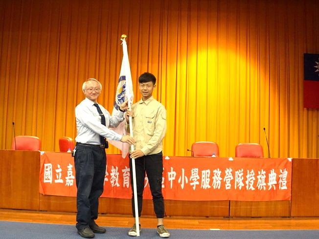 艾群校長授旗予數位學習志工社代表吳培恩同學