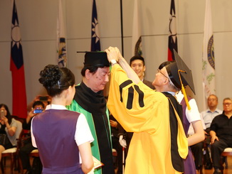 嘉大艾群校長於典禮中為獲頒名譽博士學位的張永霖先生正冠。