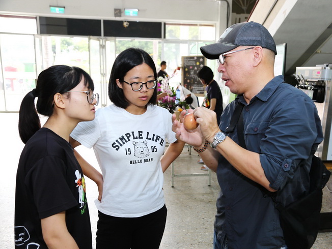 Pai-Tsang Chang, assistant professor of NCYU Department of Horticultural Science, explained tips for picking passion fruit to the visiting students.