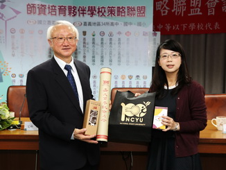 NCYU President Chyung Ay (left) presented an NCYU 100th anniversary cultural-creative gift to Lin Shu-Hua, Division Head from the Department of Education, Chiayi City Government (right). 